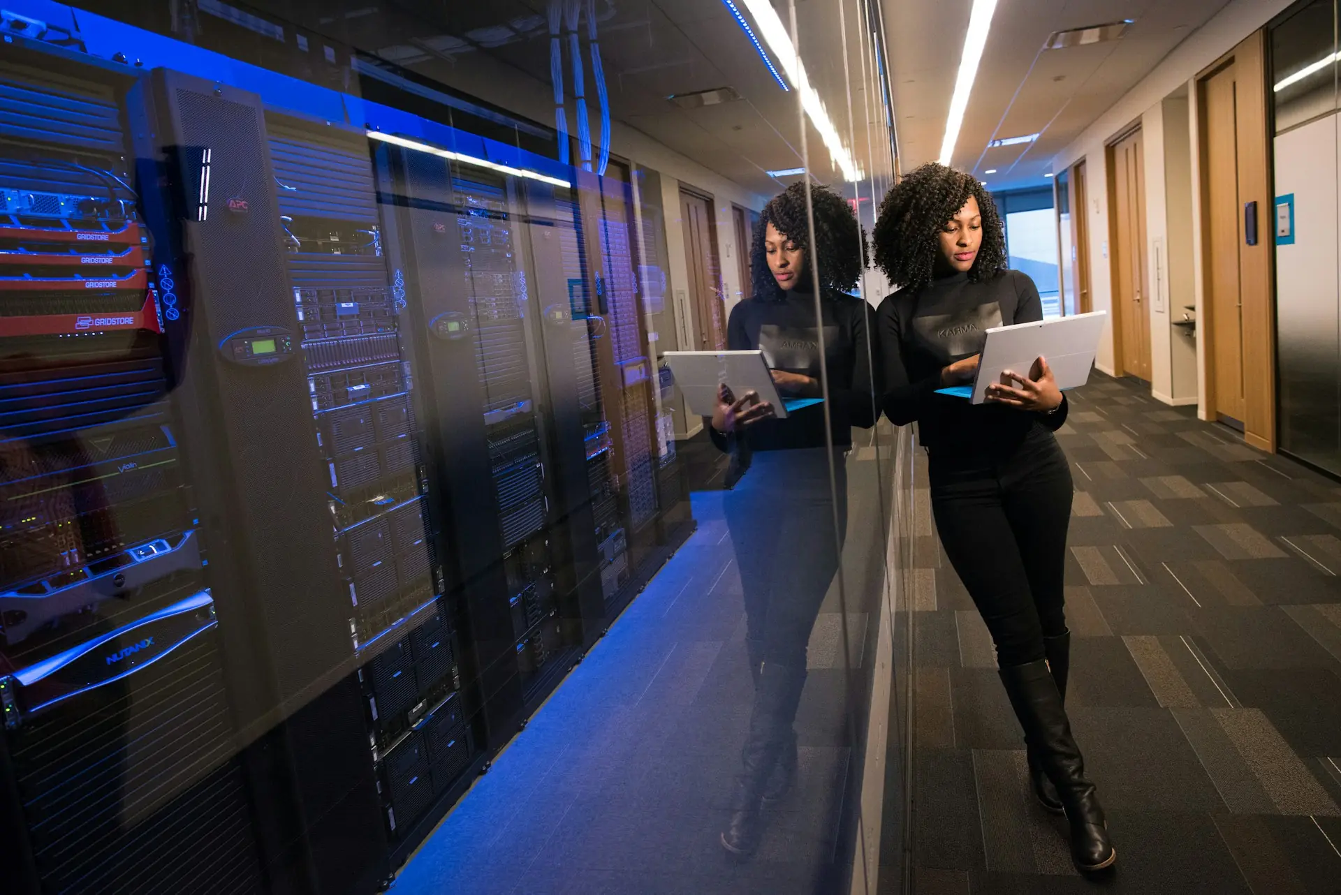 Una persona al lavoro nel corridoio di un data center, davanti agli armadi dei server